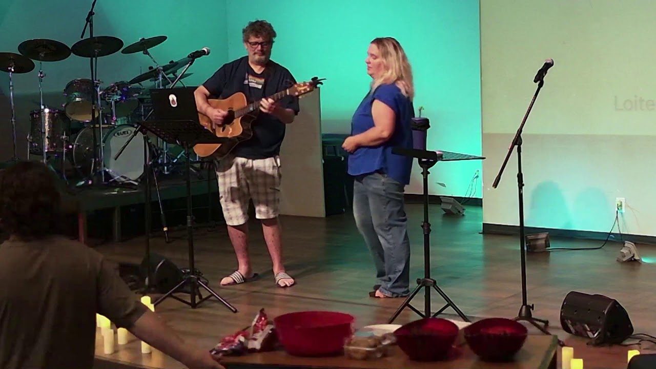Musicians leading worship on the candlelit stage